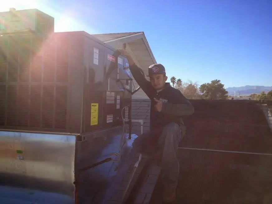 HVAC technician performing AC Tune-Up on a rooftop unit in Hampstead